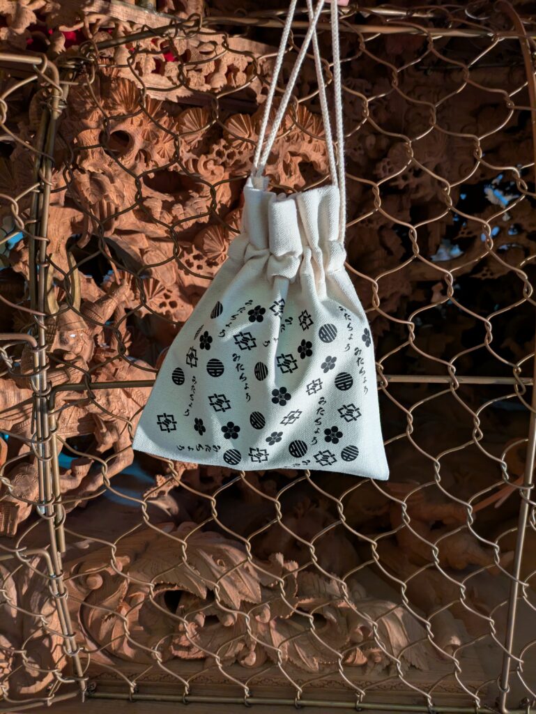 カジプリが製作したオリジナルだんじり巾着（総柄）
山直地区の三田町ロゴが散りばめられている